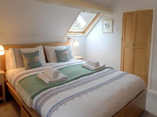 a bedroom with a bed with towels on it at Heale Cottage - 28087 in Littleham
