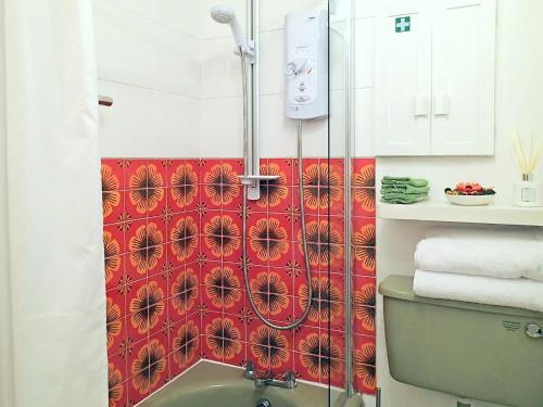 a bathroom with a shower with a red wall at Heale Cottage - 28087 in Littleham