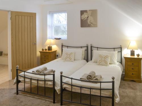 a bedroom with two beds with towels on them at Abbey Cottage in Longhirst