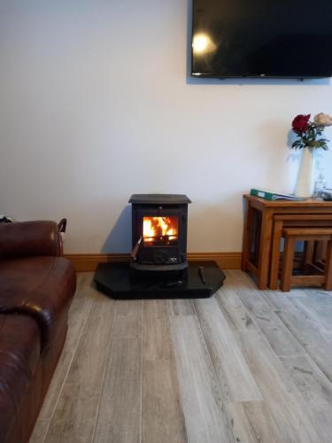 a living room with a wood stove in a room at Jack's House in Glenties