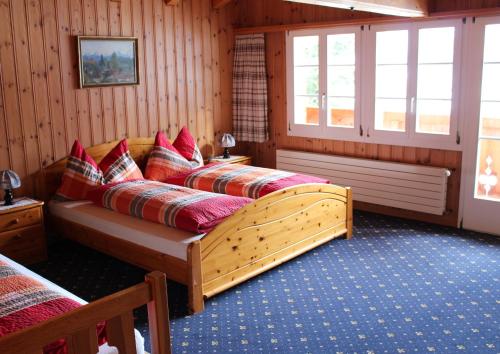 twee bedden in een kamer met houten wanden en ramen bij Chalet Spinne in Grindelwald