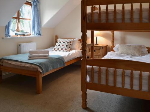 a bedroom with two bunk beds and a window at Church View in Crackington Haven
