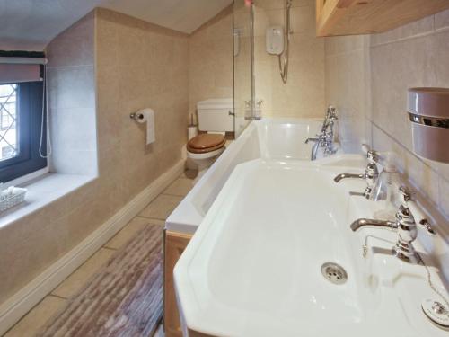 uma casa de banho com uma banheira, um lavatório e um WC. em Hidden Cottage em Spark Bridge