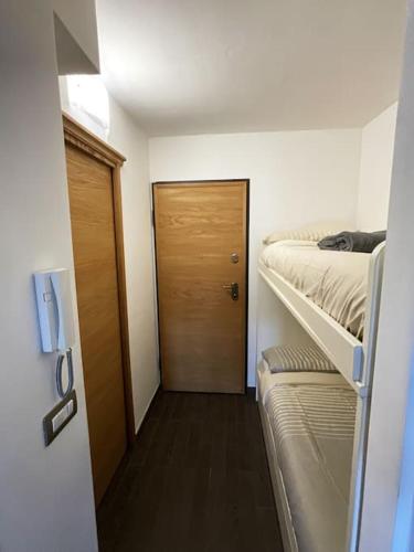 Cette chambre comprend 2 lits superposés et une porte. dans l'établissement UNO SGUARDO SULLA NATURA, à Prato Nevoso