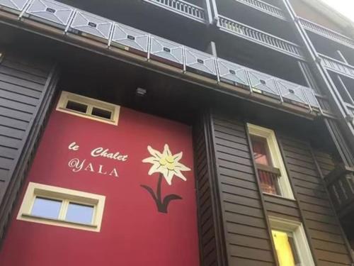 un edificio rojo con un cartel en el costado en UNO SGUARDO SULLA NATURA, en Prato Nevoso