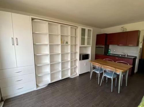 - une cuisine avec une table et des chaises dans la chambre dans l'établissement UNO SGUARDO SULLA NATURA, à Prato Nevoso