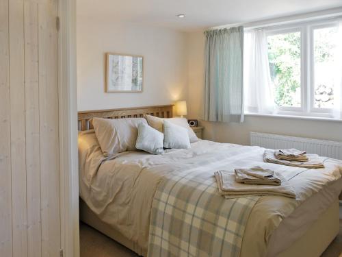 a bedroom with a large bed with towels on it at Dove Cottage in Halesworth