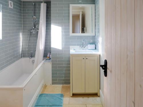 ein Badezimmer mit einer Badewanne, einem Waschbecken und einer Badewanne in der Unterkunft Dove Cottage in Halesworth