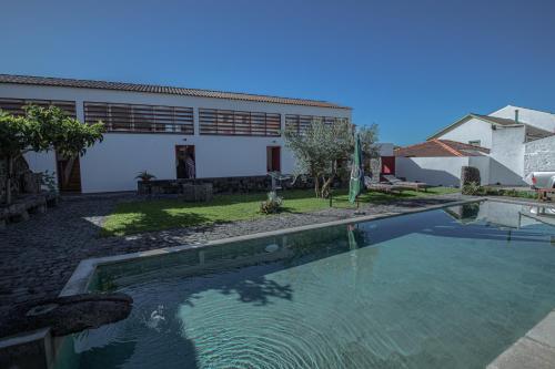 a swimming pool in front of a house at Casa do Brasão in Lajes do Pico