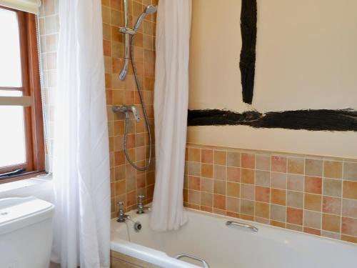 y baño con ducha y bañera. en Tudor Cottage Studio en Romsey