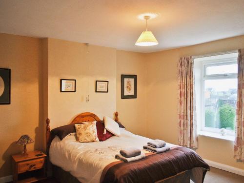 een slaapkamer met een bed met handdoeken erop bij Long Row in Hinderwell