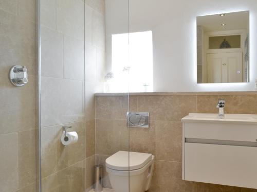 a bathroom with a toilet and a sink and a mirror at Grosvenor Cottage in Alnmouth