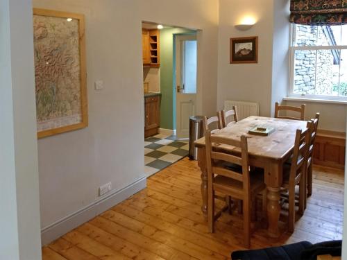 cocina y comedor con mesa y sillas en Glenmore Cottage, en Ambleside