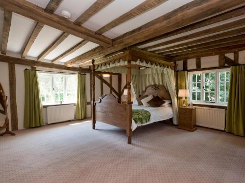 um quarto com uma cama de dossel num quarto com janelas em Cravens Manor em Sotherton