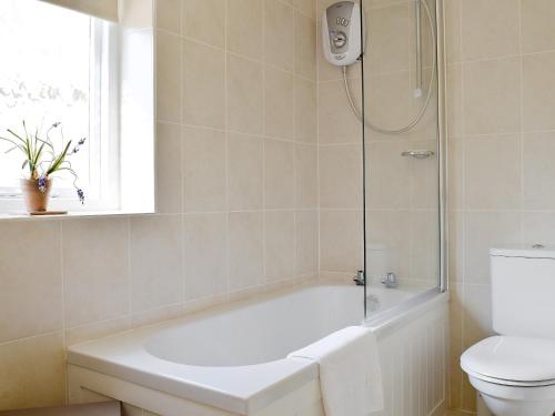 a bathroom with a bath tub and a toilet at Sikes Laithe in Kilnsey