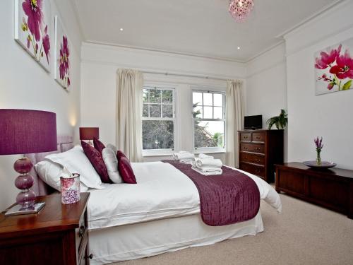 a bedroom with a large white bed and a window at Upper Knutsford in Exmouth