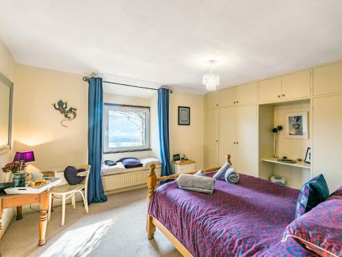 a bedroom with a bed and a desk and a window at Carries Gate in Coniston