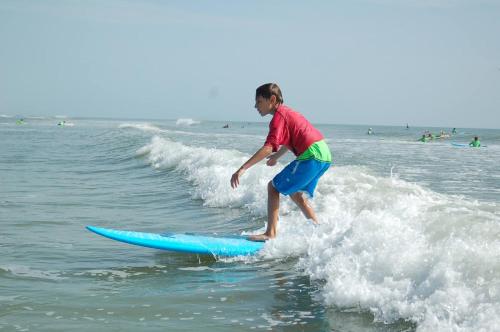 a young boy riding a wave on a surfboard in the ocean at Ocean View Happy Hill in Olón