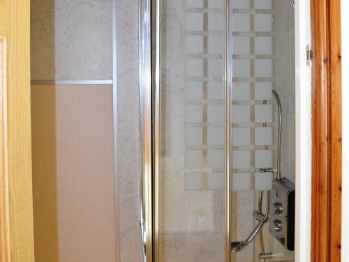a shower with a glass door in a bathroom at The Old Dairy in Crosscanonby