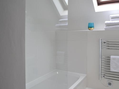 a white bathroom with a shower with a glass door at Sunset in Cheriton Bishop