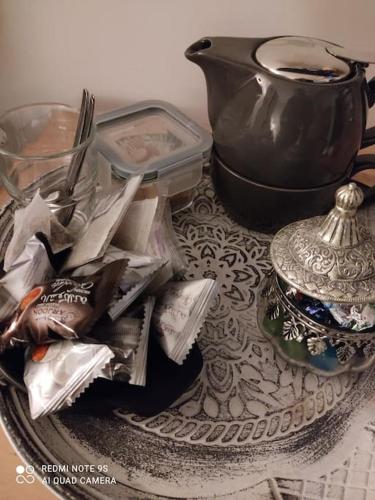 a table topped with a plate with a tea pot and a bowl at logement Mezzanine salon indépendant in Mézières-sur-Seine