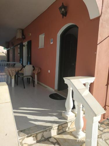 a porch of a house with a black door at Gerekos Studios and Apartments in Agios Georgios