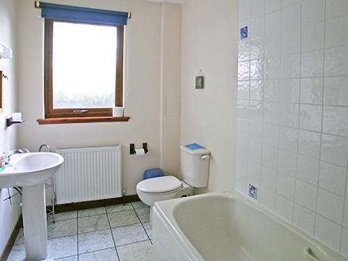 uma casa de banho com uma banheira, um WC e um lavatório. em Scobach Lodge em Turriff