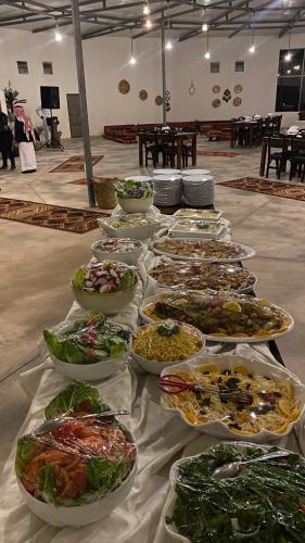 a table with many plates of food on it at RUM FLORAA LUxURY CAMP in Wadi Rum