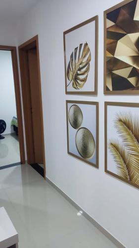 a row of framed art on a wall in a room at Mirantes caminho do mar in Parnamirim