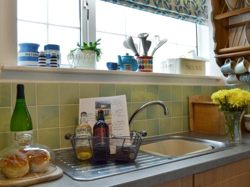a kitchen sink with a basket of wine bottles at The Blue Loft in Rye