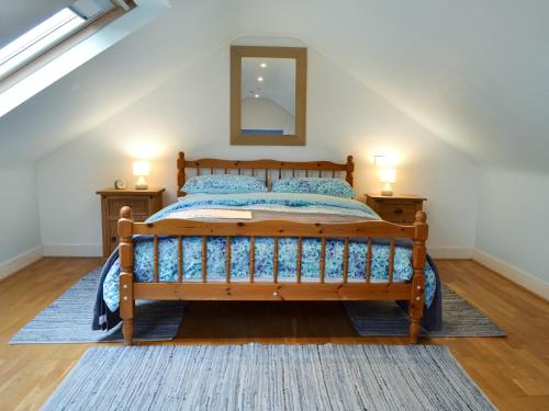 a bedroom with a wooden bed and two night stands at The Blue Loft in Rye
