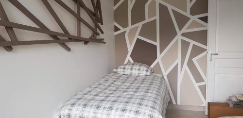 a bedroom with a geometric accent wall and a bed at Le champ des granges in Briare