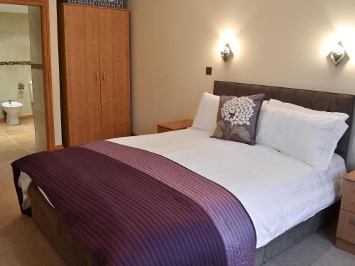 a bedroom with a large bed with a purple blanket at Tidal Crest in Nottingham