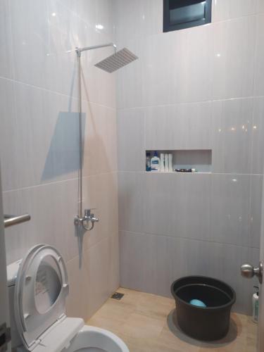 ein Badezimmer mit einem WC und einem schwarzen Eimer in der Unterkunft Villa Sky Garden in Bogor
