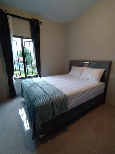 a bed in a bedroom with a large window at Villa Sky Garden in Bogor