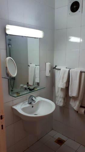 a bathroom with a sink and a mirror and towels at New Pola Hotel in Luxor
