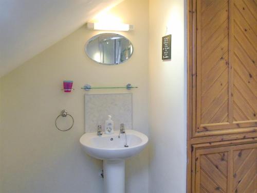 y baño con lavabo y espejo. en Ysgubor Uchaf - 29517, en Fairbourne