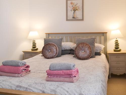 a bedroom with a bed with towels on it at Sweet Pea Cottage- 28322 in Holt