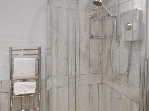 a bathroom with a shower with a glass door at Haven Cottage - 28269 in Port Isaac