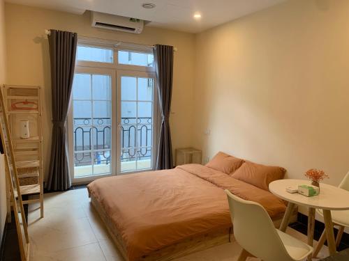 1 dormitorio con cama, mesa y ventana en Mino Homestay, en Hanói