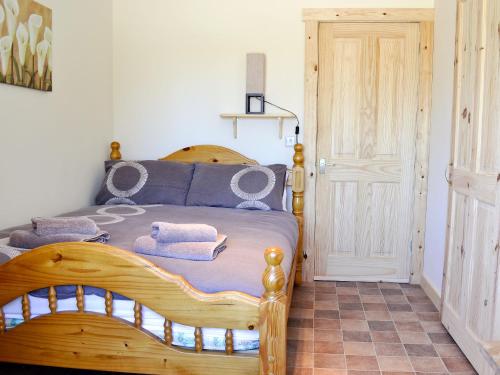 1 dormitorio con cama de madera y toallas en Fishermans Retreat, en Old Leake