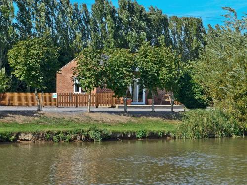 un edificio junto a una masa de agua en Fishermans Retreat, en Old Leake