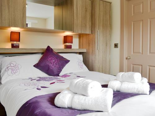 a bedroom with a large bed with towels on it at Robin Cottage in Llandeilo