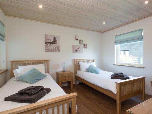 a bedroom with two beds and a window at Broad Reach - 28121 in Fritton