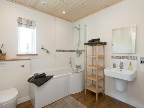 a bathroom with a tub and a sink and a toilet at Broad Reach - 28121 in Fritton