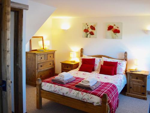 a bedroom with a bed with red pillows at Bramble in Hartland