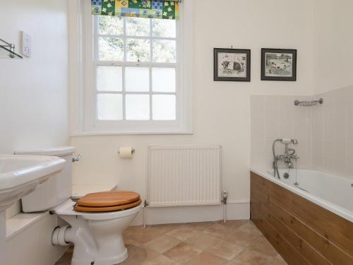 a bathroom with a toilet and a sink and a tub at The Old Butlers House in Cley next the Sea