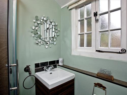 bagno con lavandino e specchio di Sea Glass Cottage a Dawlish
