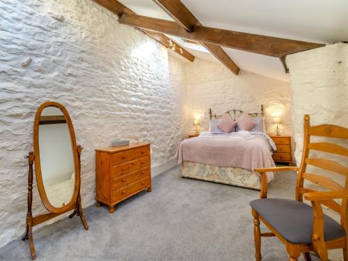 ピカリングにあるBow Cottageのベッドルーム1室(ベッド1台、鏡、椅子付)