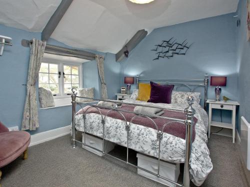 una camera con letto e parete blu di Sea Glass Cottage a Dawlish